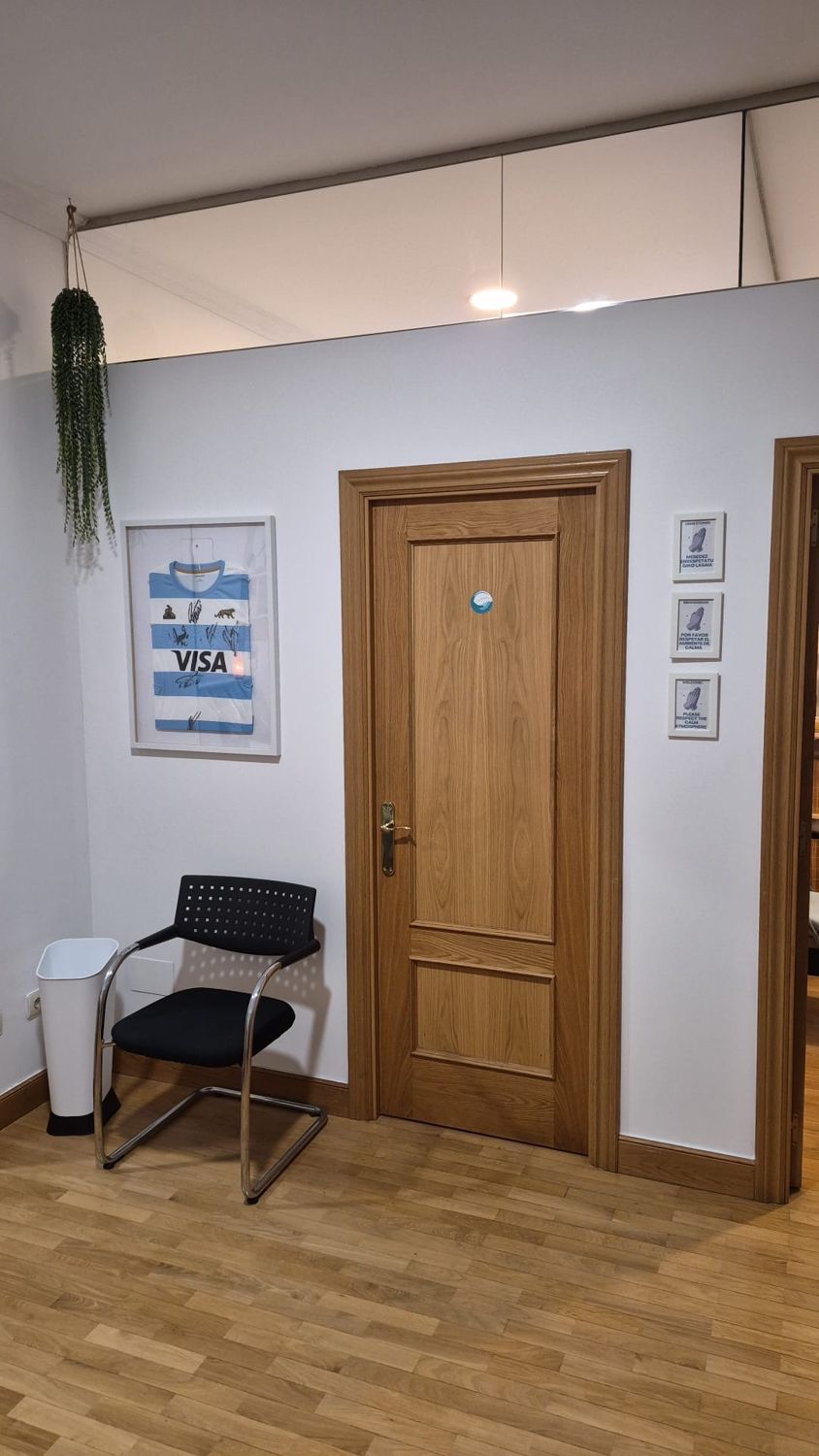 Pasillo hacia la sala de tratamiento, con carteles que piden respetar el ambiente de calma